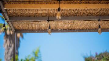 A ceiling with woven material and hanging light bulbs.
