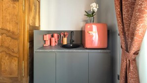A kitchen with a wooden cabinet, a pink refrigerator, and a sink. - Cinisca Suite Blue in Bologna (Bologna)