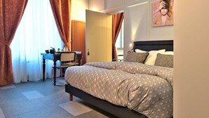 A bedroom with a large bed, a desk, and a chair. - Cinisca Suite Blue in Bologna (Bologna)