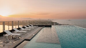 An infinity pool with lounge chairs and a view of the sea and mountains. - Plott The One Sokcho Xiella The Beach (Sokcho)