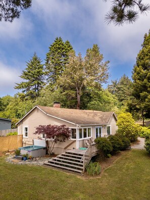 A single-story house with a front porch, a small deck, and a visible outdoor hot tub. - Peaceful Seaside Farmhouse, near Moonstone Beach and Redwood National Park (Trinidad)