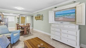 A living room with a television, a dining table, and a sofa. - 510 - Cozy 1 bedroom Fantastic View (New Smyrna Beach)