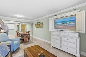 A living room with a television, a dining table, and a sofa. - 510 - Cozy 1 bedroom Fantastic View (New Smyrna Beach)