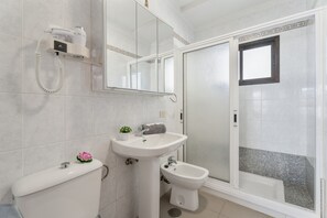 A bathroom with a toilet, bidet, sink, and a shower area. - Vacation Apartment "Golden Sun Penthouse" with Shared Pool, Private Terrace & Wi-Fi (Playa de las Américas)