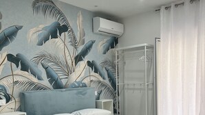 A bedroom with a bed, a shower, and a wall with a tropical leaf mural. - Casa Margherita  (Naples)