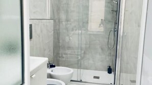 A modern bathroom with a glass-enclosed shower, a white sink, and a toilet. - Casa Margherita  (Naples)