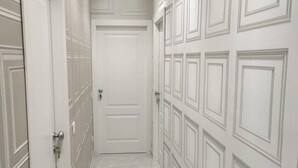 A hallway with white doors and a marble floor. - Casa Margherita  (Naples)