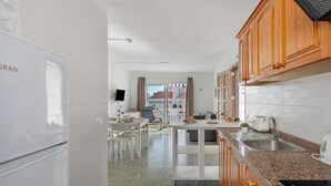 A modern kitchen with white cabinets, a granite countertop, and a built-in oven. - Ocean Breeze Penthouse Apartment with Shared Pool, Private Terrace and Wi-Fi (Playa de las Américas)