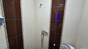 A small bathroom with a white sink, a toilet, and a shower. - Üsküdar Hotel Batum (Batumi)