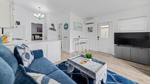 A modern living room with a blue sofa, a coffee table, and a TV. - Waterway Vista Suite Pet Friendly Boat Dock (Indian Rocks Beach)