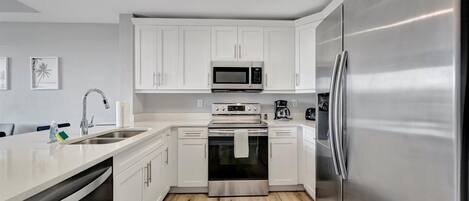 A modern kitchen with white cabinets, stainless steel appliances, and a dishwasher.