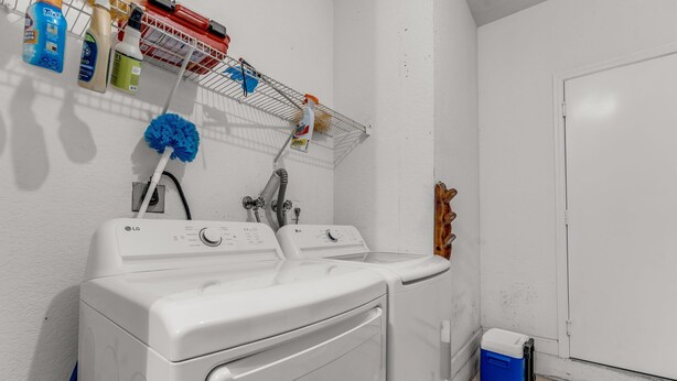 A laundry area with two white LG washing machines, a drying rack with cleaning supplies, and a blue cooler on wheels. - Waterview Villa Sleeps 10 BBQ Kayaks Games (Miami)