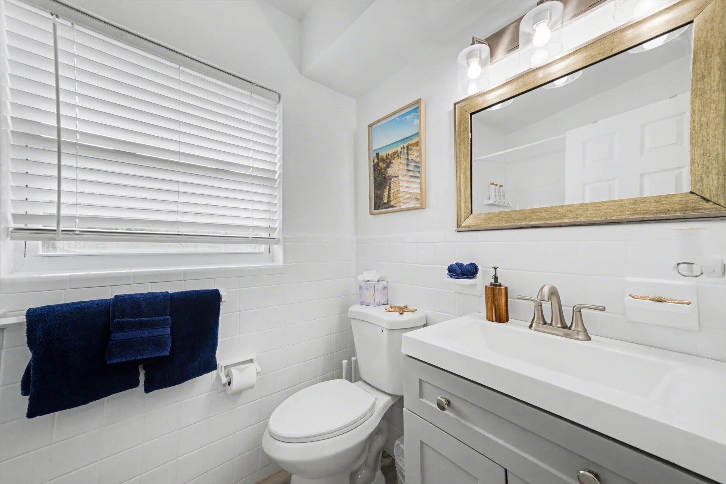 Un baño con inodoro, lavamanos y espejo.