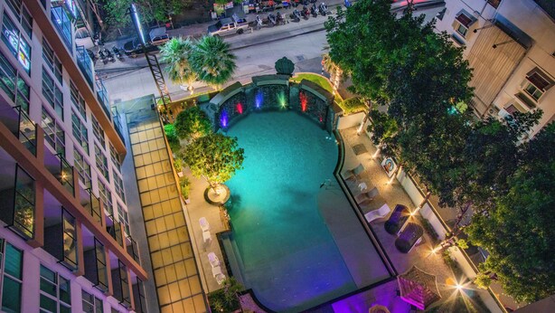Vista aérea de un patio con piscina, rodeado de edificios y zonas de estar al aire libre.