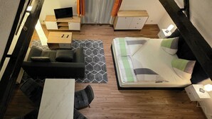 Une petite pièce comprenant un lit, un bureau, une chaise et un canapé.