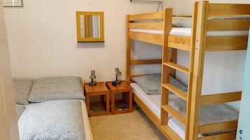 Habitación con literas, un escritorio y dos lámparas.