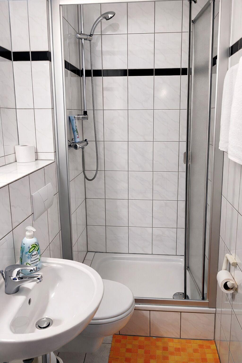 A bathroom with a shower, toilet, and sink.