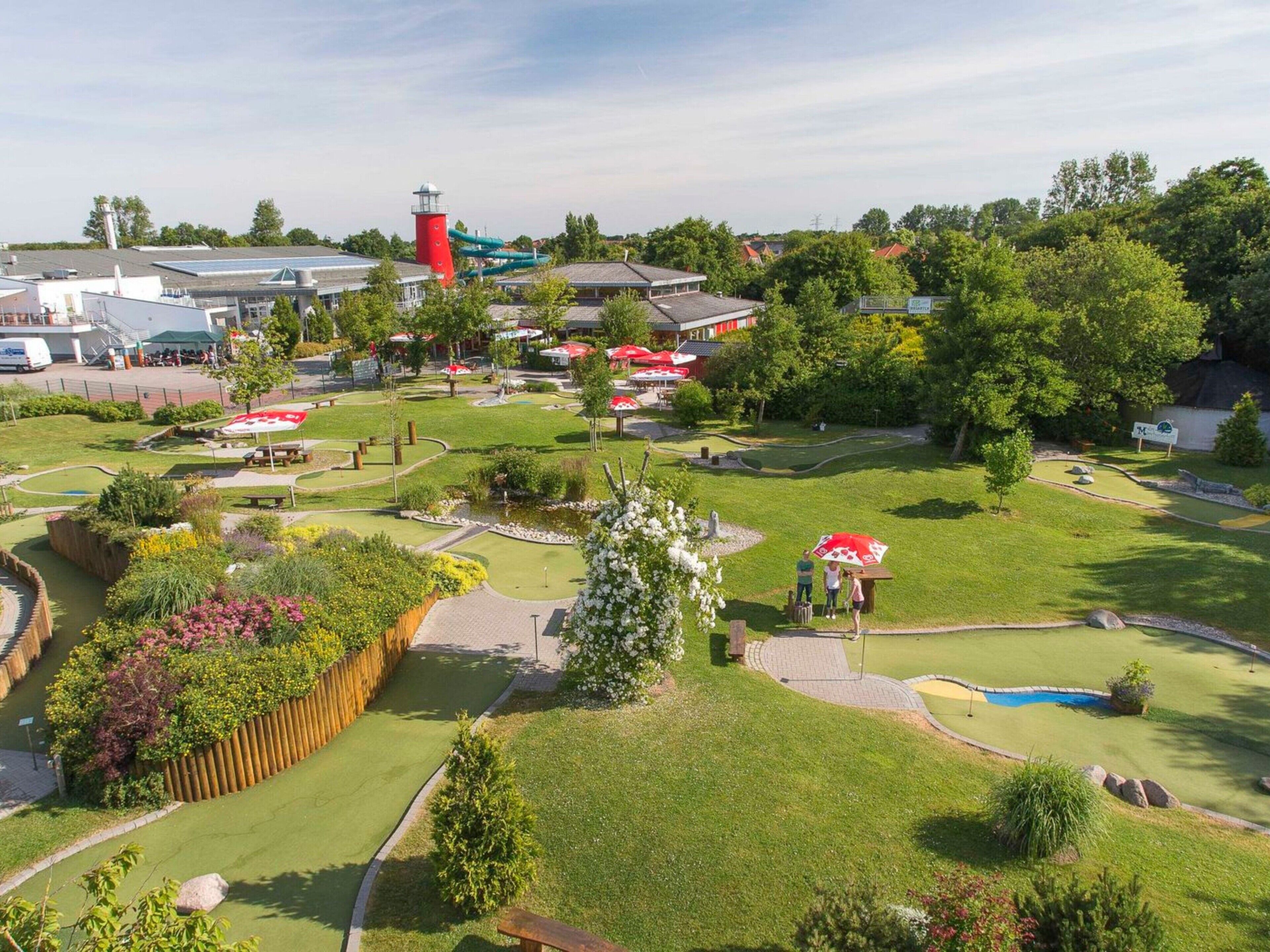 A golf course with a water slide, picnic areas, and a lighthouse.