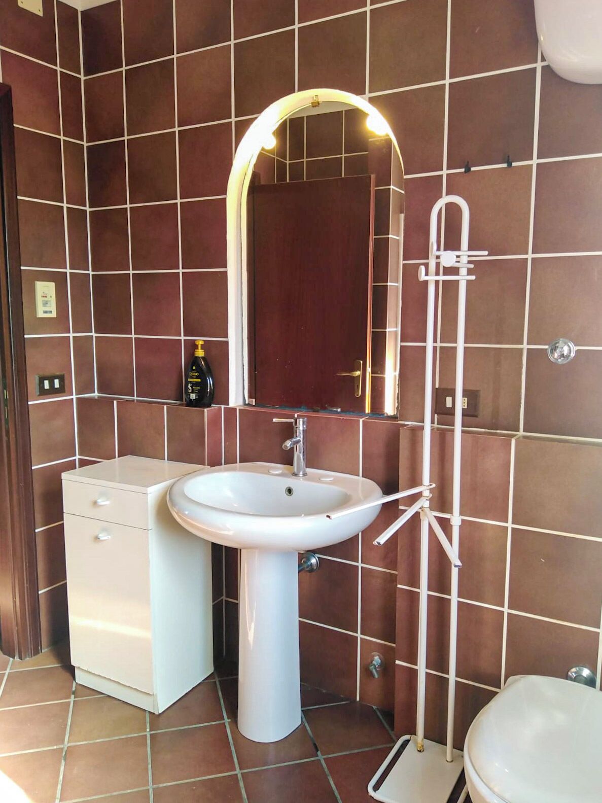 Un baño con lavamanos blanco, un espejo, inodoro y ducha.