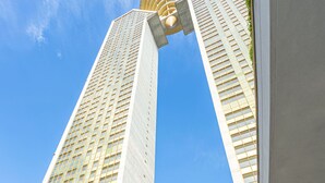 Um edifício moderno com duas torres altas interligadas por uma estrutura curva.