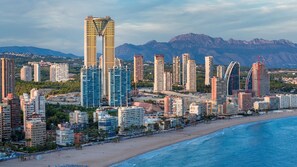 A coastal cityscape with high-rise buildings, a beach, and mountains in the background. - Intempo by Holuxe - 015 - 1st floor (Benidorm)
