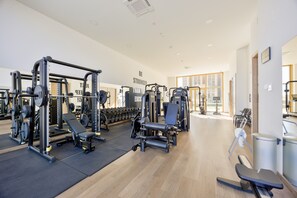 A gym with various exercise equipment, a bench, and dumbbells. - Intempo by Holuxe - 015 - 1st floor (Benidorm)