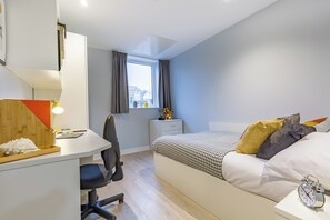 A modern bedroom with a desk, chair, and a neatly made bed. - Student Only Mary Parker House (Plymouth)