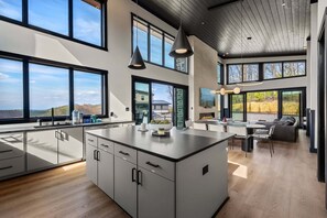 Una cocina moderna con ventanas amplias, un comedor y una chimenea.