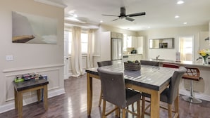 A dining area with a marble table, wooden chairs, and a small side table with boxes. - Pet Friendly! 3-story Home Near Cobbs Creek Park! (Philadelphia)