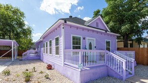 A purple house with a porch and a small garden. - Walk to Alamodome! Stylish Home w/ Private Parking (San Antonio)