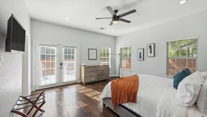 A bedroom with a bed, a ceiling fan, a radiator, and a window with blinds. - Walk to Alamodome! Stylish Home w/ Private Parking (San Antonio)