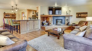 A spacious living room with a fireplace, a kitchen area with wooden cabinets, and a seating area with leather sofas and chairs. - 2 Mtn-view Decks! East Vail Unit By Trails & Bus (Vail)