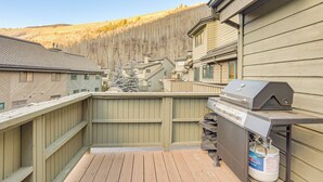 A deck with a barbecue grill and propane tank, surrounded by wooden fencing and a view of a mountainous landscape. - 2 Mtn-view Decks! East Vail Unit By Trails & Bus (Vail)