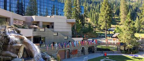 A hotel with a waterfall, a pool, and a tennis court.