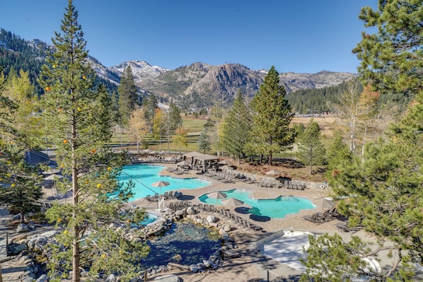 A resort with multiple swimming pools, a hot tub, and a mountainous backdrop. - Olympic Valley Ski Base w/ On-site Ice Skating! (Olympic Valley)
