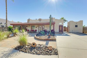 A building with a red-tiled roof, a cactus garden, and a stone pathway leading to the entrance. - Mtn-view Casita w/ Rooftop Deck & Patio in Yuma! (Yuma)