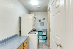 A compact kitchen with a built-in washer and dryer, a small countertop, and a door leading to a bathroom. - Mtn-view Casita w/ Rooftop Deck & Patio in Yuma! (Yuma)