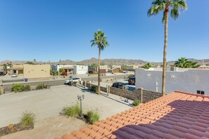 A residential area with a clear sky, a parking lot, and a few palm trees. - Mtn-view Casita w/ Rooftop Deck & Patio in Yuma! (Yuma)
