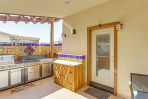 Una cucina compatta con piano cottura integrato, un bancone in legno e un lavello.