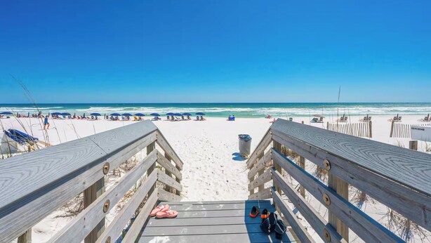 A wooden boardwalk leading to a sandy beach with umbrellas and lounge chairs. - 2 BR Condo w/ Shared Pool & Beach Access (Fort Walton Beach)
