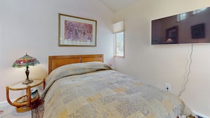 A bedroom with a bed, a bedside lamp, a framed picture on the wall, and a television mounted on the wall. - 4 BR Home w/ Pool, Hot Tub, Fireplaces, Grills (Arroyo Seco)
