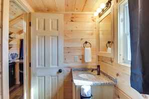 A wooden interior with a bathroom featuring a sink, mirror, and towel ring. - Sweet Thang: Romantic Blue Ridge Mtns Getaway (Union Mills)
