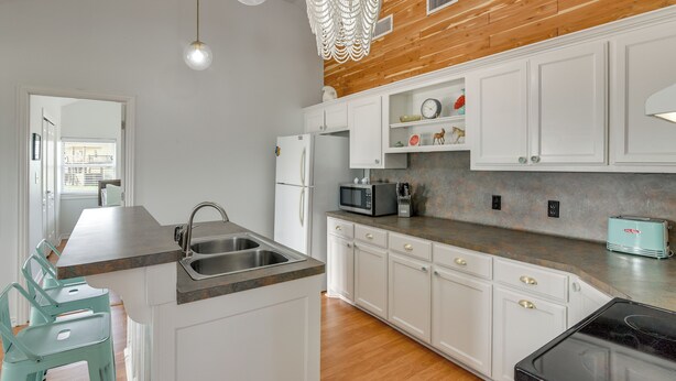 A modern kitchen with white cabinets, a wooden ceiling, and a built-in microwave. - Steps to Sea! Crystal Beach Home w/ Furnished Deck (Port Bolivar)