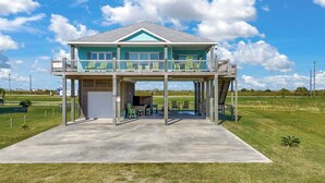Une maison à deux étages avec un balcon, un garage et une allée en béton.