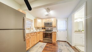 A kitchen with wooden cabinets, stainless steel appliances, and a wooden floor. - Walk to Gotl Strip! Family Cottage w/ Laundry (Geneva)