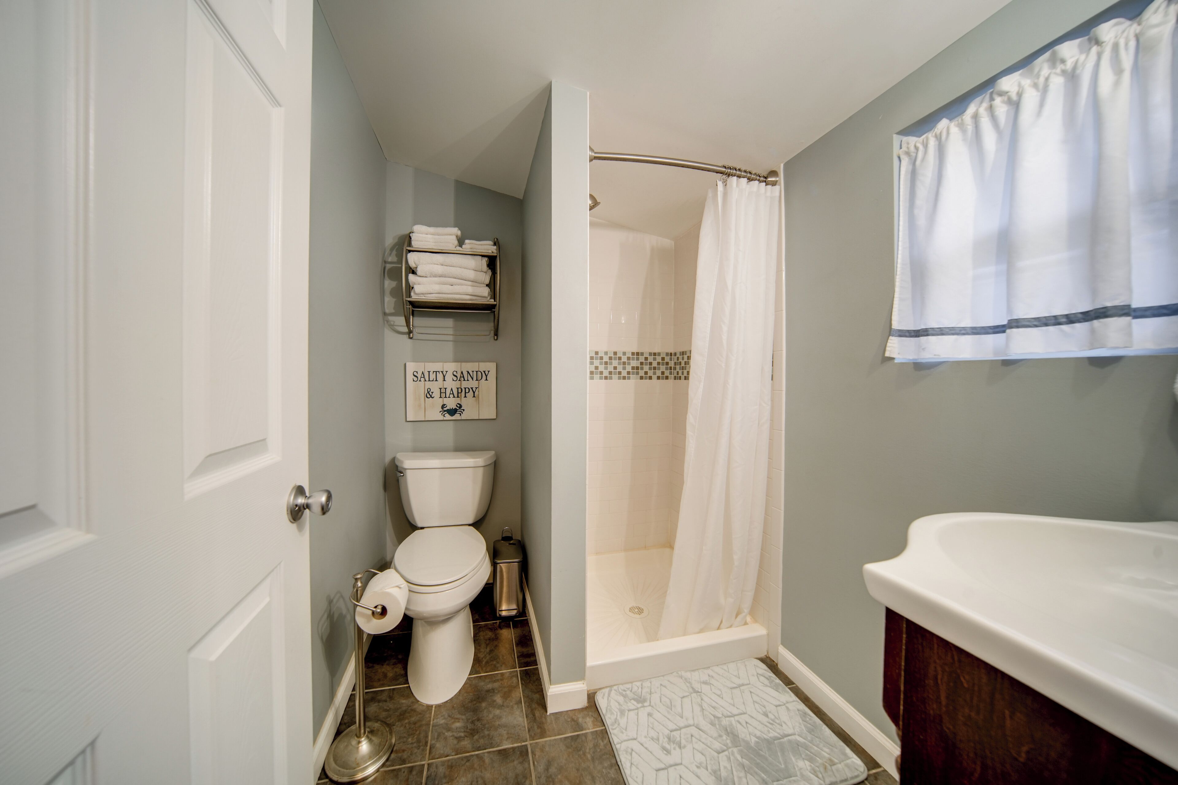 A bathroom with a toilet, a shower, and a sink.