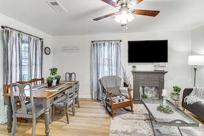 A dining area with a wooden table and chairs, a fireplace, and a television mounted on the wall. - 1 Mi to Lake Hamilton! Newly Remodeled Family Home (Hot Springs)