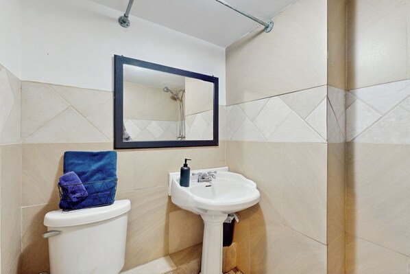 Une salle de bain avec des toilettes, un lavabo et un miroir.