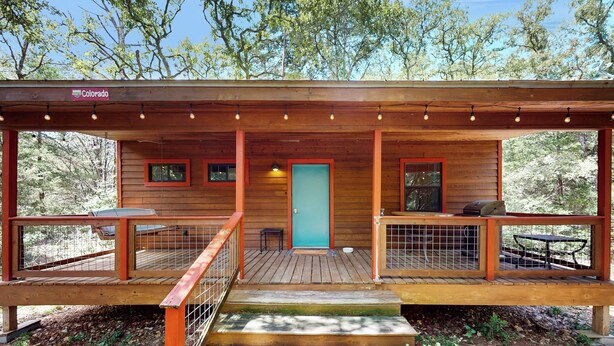 A wooden cabin with a porch, a door, and a sign indicating 'Colorado'. - Serene & Secluded Paige Cabin: Dogs Welcome! (Paige)