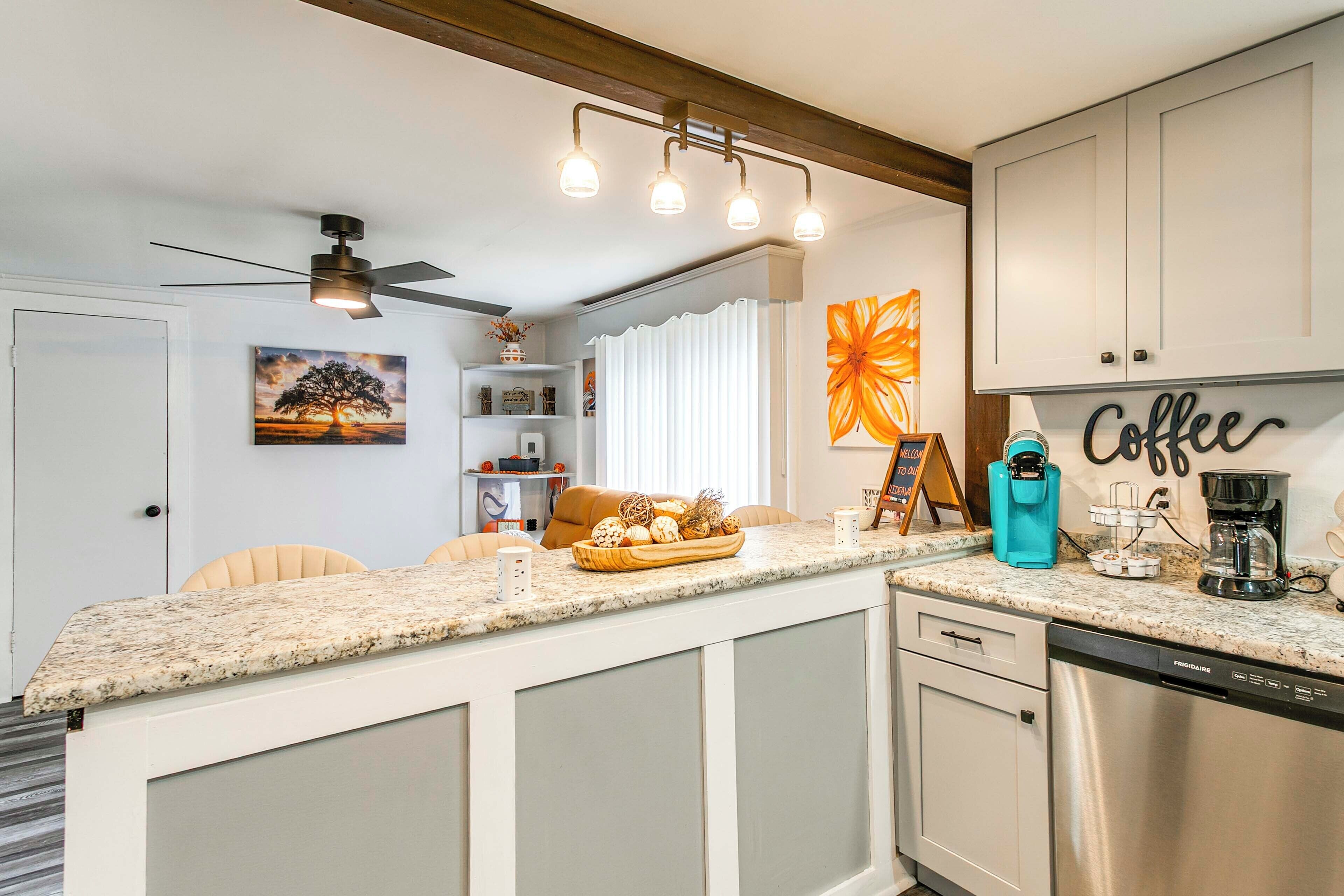 A kitchen with a granite countertop, a coffee machine, and a dishwasher.